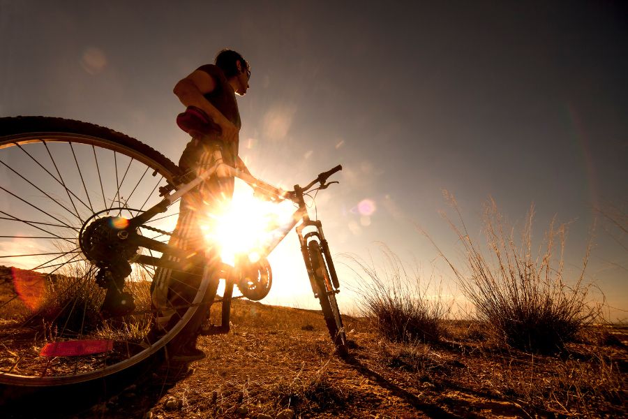 un ciclista con su bici al atardecer